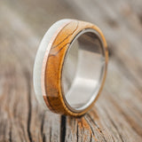 Shown here is "Golden", a custom, handcrafted men's wedding ring featuring spalted maple and antler overlay divided by a hammered 14K rose gold inlay, upright facing left. Additional overlay options are available upon request.