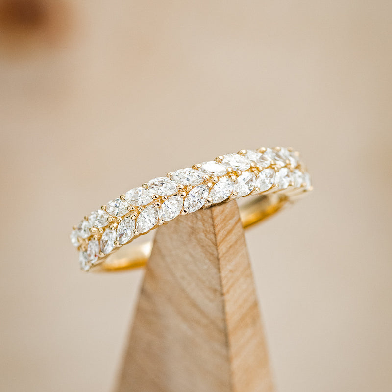 Shown here is "Esmeree", a custom, handcrafted women's stacking wedding band featuring marquise diamond accents, on stand front facing.