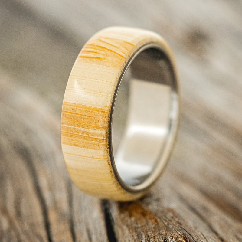 Shown here is "Haven", a custom, handcrafted men's wedding ring featuring a bamboo baseball bat overlay on a titanium band, design right facing. Additional overlay options are available upon request.