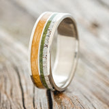 Shown here is "Dyad", a custom, handcrafted men's wedding ring featuring 2 channels with moss, elk antler, and whiskey barrel oak inlays on a titanium band, design shown facing right. Additional inlay options are available upon request.