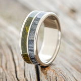 Shown here is "Dyad",  a custom, handcrafted men's wedding ring featuring 2 channels with mossy patina copper and grey birch wood inlays, shown facing right. Additional inlay options are available upon request.