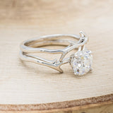 Shown here is "Artemis", a moissanite women's engagement ring with an antler/branch style stacking band, facing right. Many other center stone options are available upon request.