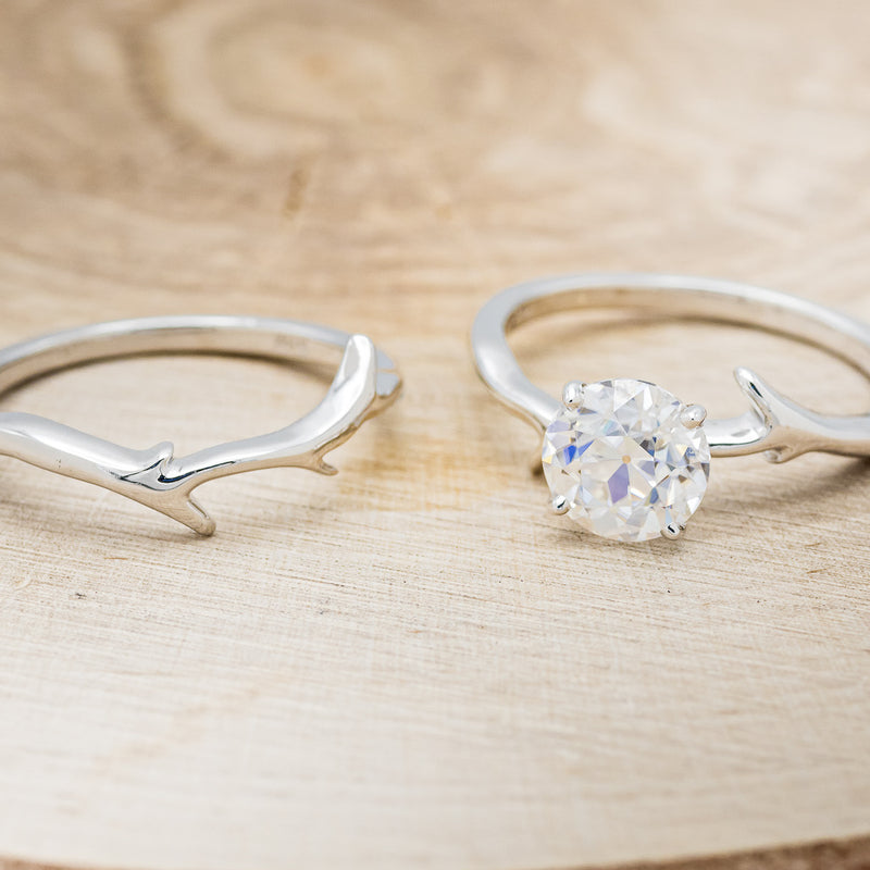 Shown here is "Artemis", a moissanite women's engagement ring with an antler/branch style stacking band, laying together. Many other center stone options are available upon request.