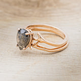 Shown here is "Artemis", a women's engagement ring with an antler-style stacking band displayed here with a pear-shaped salt and pepper diamond but listed here as a mounting-only option, facing left. Follow the instructions above to select your stone.