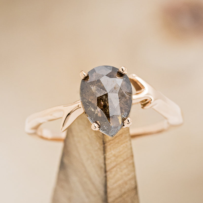 Shown here is "Artemis", a women's engagement ring with an antler-style band displayed here with a pear-shaped salt and pepper diamond but listed here as a mounting-only option, on stand front facing. Follow the instructions above to select your stone.