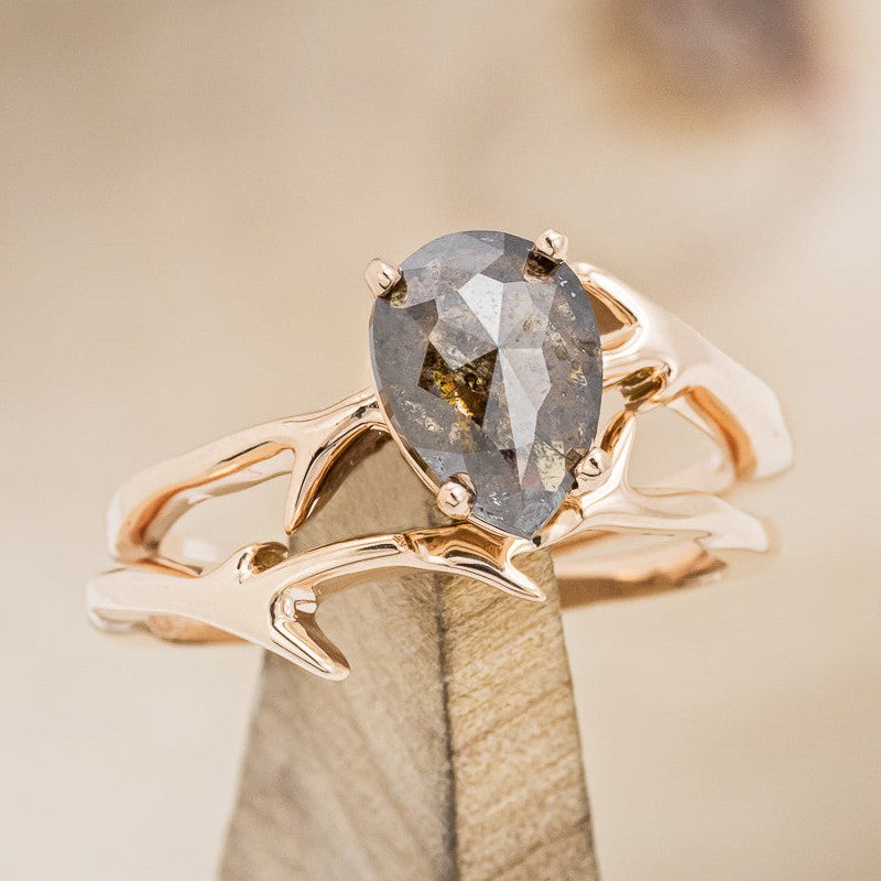 Shown here is "Artemis", a women's engagement ring with an antler-style stacking band displayed here with a pear-shaped salt and pepper diamond but listed here as a mounting-only option, on stand front facing. Follow the instructions above to select your stone.
