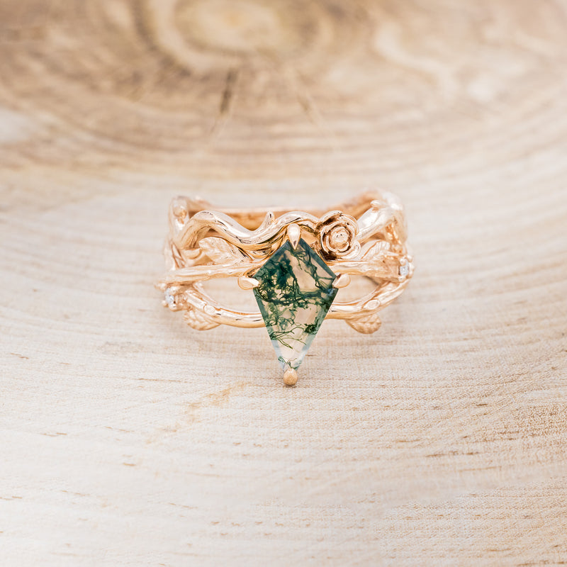 Shown here is "Artemis on the Vine", a branch-style moss agate women's engagement ring with diamonds, leaf accents and a floral tracer, front facing. Many other center stone options are available upon request.