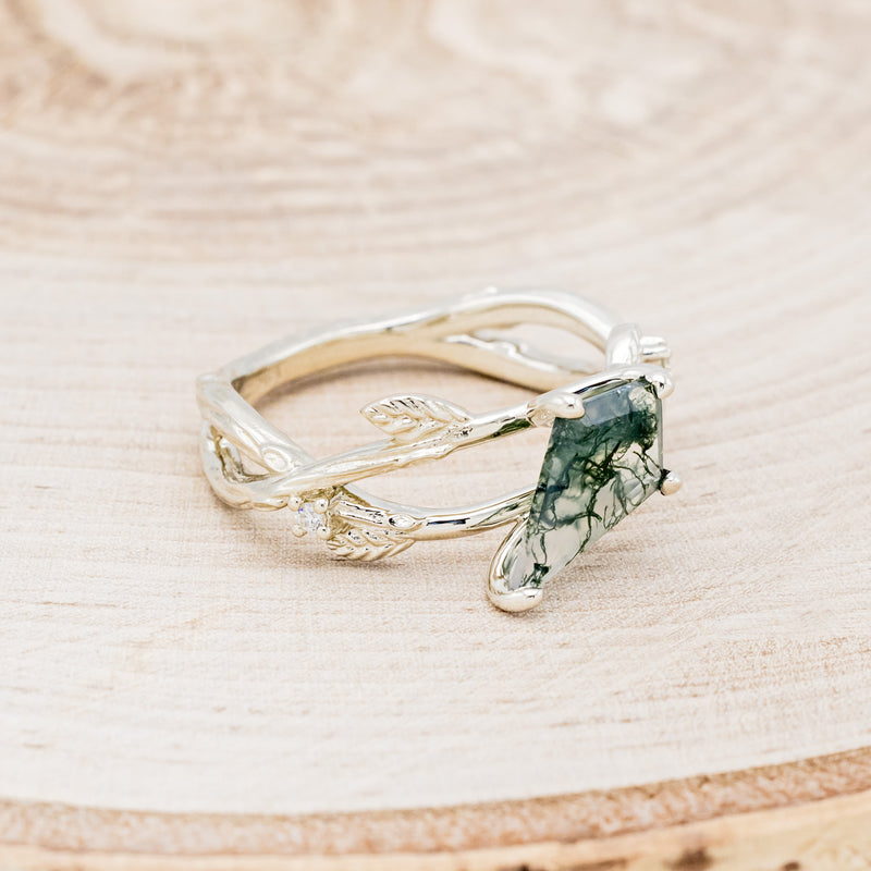 Shown here is "Artemis on the Vine", a branch-style moss agate women's engagement ring with diamond and leaf accents, facing right. Many other center stone options are available upon request.