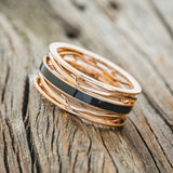 Shown here is men's "Artemis", a custom, handcrafted men's wedding ring featuring a single channel with a jet stone inlay, tilted left. Additional inlay options are available upon request.