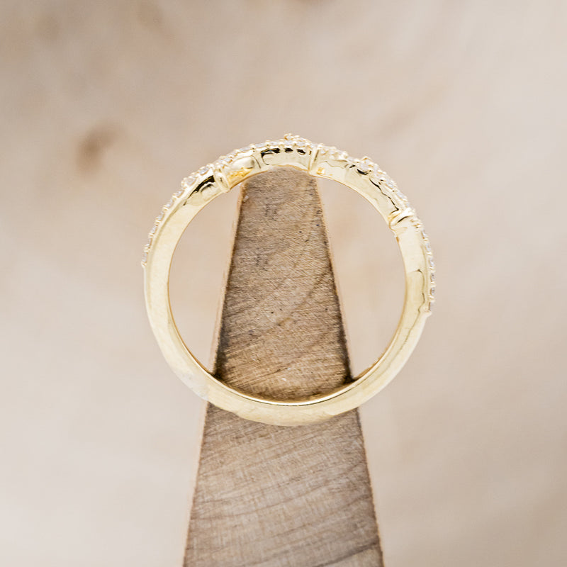 Shown here is "Artemis", a stacking ring with pavé diamonds and an antler/branch style band, side profile on stand. Additional stone options are available upon request.