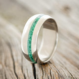 Shown here is "Vertigo", a custom, handcrafted men's domed wedding ring featuring an offset malachite inlay, upright facing left. 
