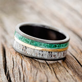 Shown here is "Raptor", a handcrafted men's wedding ring featuring two channels with malachite and antler inlays divided by a 14K yellow gold inlay, tilted left. Additional inlay options are available upon request.
