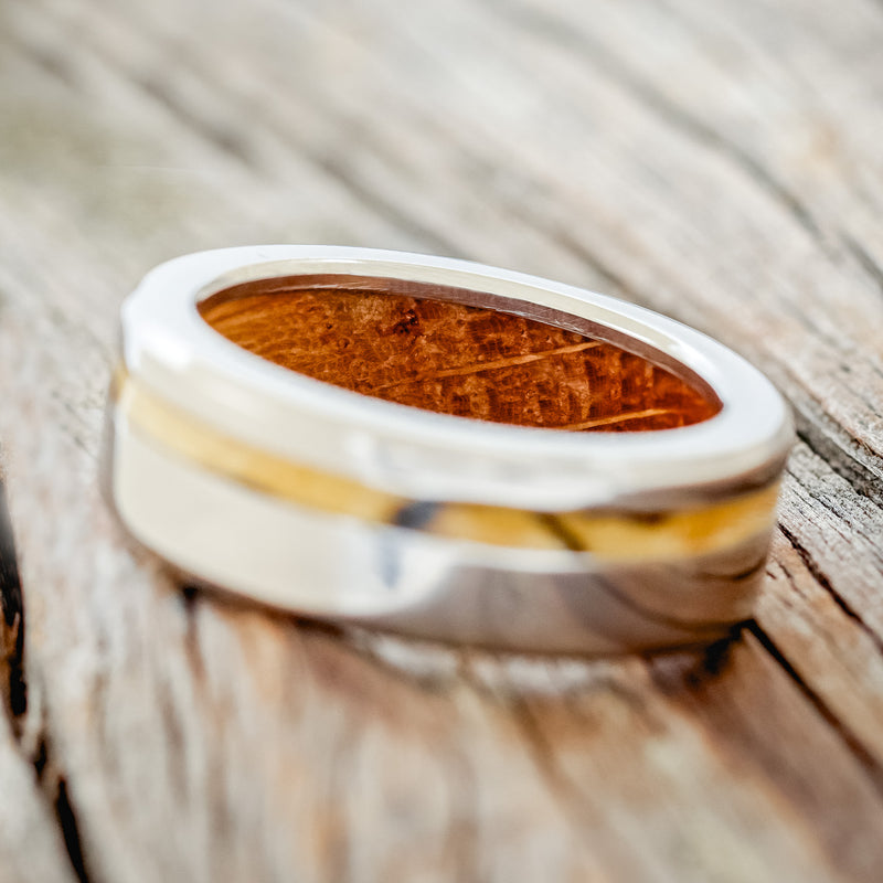 Shown here is "Vertigo", a handcrafted men's wedding ring featuring a spalted maple inlay on a whiskey barrel lined titanium band, tilted left. Additional inlay options are available upon request.