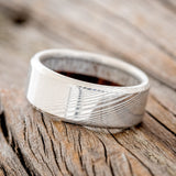Shown here is a custom, handcrafted men's wedding ring featuring an elk antler and redwood lining, tilted left. Additional lining options are available upon request.