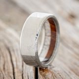 Shown here is a custom, handcrafted men's wedding ring featuring an elk antler and redwood lining, upright facing left. Additional lining options are available upon request.