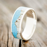 Shown here is "Helios", a handcrafted men's wedding ring featuring a mountain range using antler and a turquoise inlay, upright facing left. Additional inlay options are available upon request.
