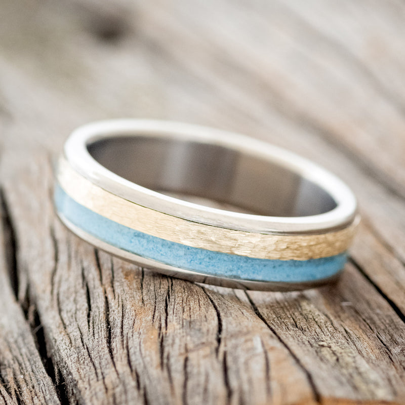 Shown here is a custom, handcrafted men's wedding ring featuring turquoise and hammered 14K yellow gold inlay, tilted left. Additional inlay options are available upon request.