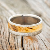 "Tanner" is a custom, handcrafted men's wedding ring featuring a spalted maple wood inlay with a hammered band, laying flat. Additional inlay options are available upon request.