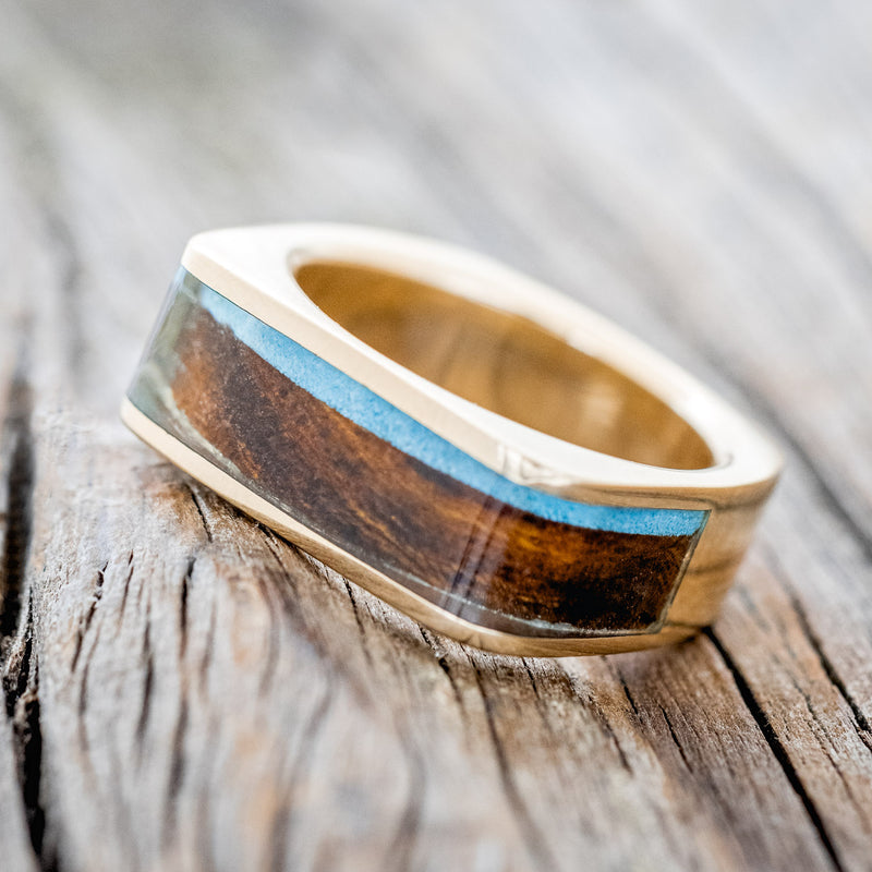 Shown here is "Mesa", a custom, handcrafted men's wedding band featuring a flat top 14K gold band with ironwood and turquoise inlays, tilted left. Additional inlay options are available upon request.