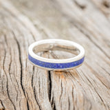 Shown here is "Perenna", a custom, handcrafted women's stacking band featuring a lapis lazuli inlay on a 14K gold band, laying flat. Additional inlay options are available upon request.