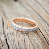 Shown here is "Perenna", a custom, handcrafted women's stacking band featuring a fire and ice opal inlay on a 14K gold band, tilted left. Additional inlay options are available upon request.