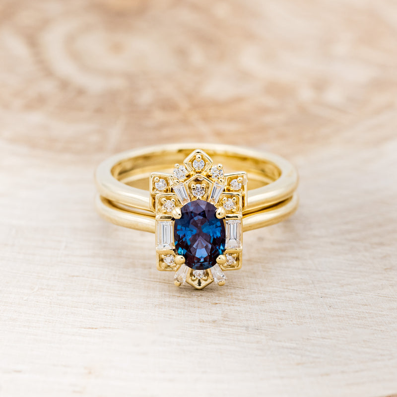 Shown here is "Cleopatra", an art deco-style oval lab-created alexandrite women's engagement ring with diamond accents and a diamond tracer, front facing. Many other center stone options are available upon request.