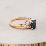 Shown here is "Blossom", an oval lab-created alexandrite women's engagement ring with leaf-shaped diamond accents, facing right. Many other center stone options are available upon request.