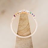 Shown here is "Reign", a marquise diamond tracer with rainbow accent stones, side view on stand. This tracer is made to go with some of our engagement rings (email for options)