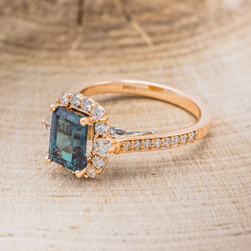 Shown here is "Ophelia", a lab-created alexandrite women's engagement ring with a diamond halo and diamond accents, facing left. Many other center stone options are available upon request.