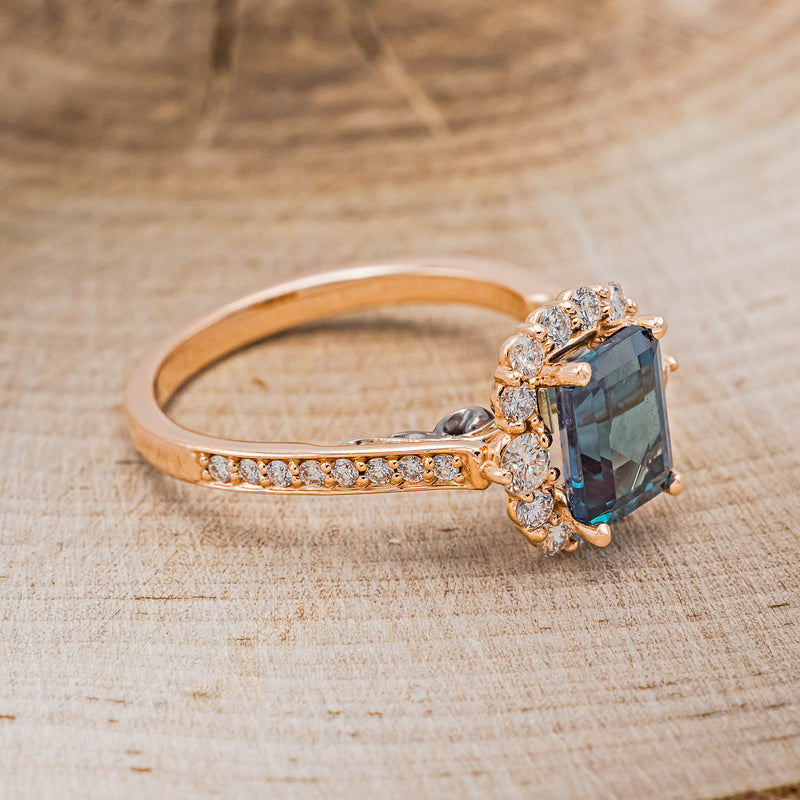 Shown here is "Ophelia", a lab-created alexandrite women's engagement ring with a diamond halo and diamond accents, facing right. Many other center stone options are available upon request.