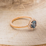 Shown here is "Coralie", a women's engagement ring with a lab-created alexandrite center stone with a starburst diamond halo, facing right. Many other center stone options are available upon request.