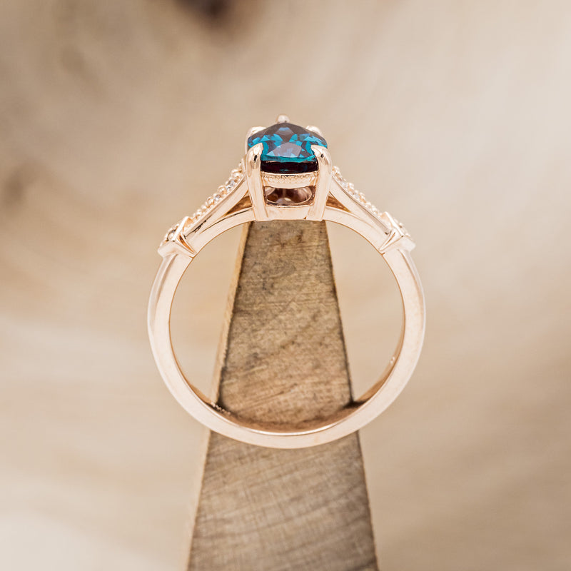  Shown here is "Annora", an accented-style lab-created alexandrite women's engagement ring with diamond and black diamond accents, side view on stand. Many other center stone options and shapes are available upon request.
