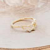 Shown here is "Zodiac", a custom, handcrafted women's stacker featuring a Capricorn constellation on a 14K gold band, facing right. People born between the dates of December 22nd – January 19th are a Capricorn.
