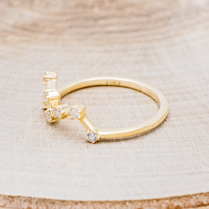 Shown here is "Zodiac", a custom, handcrafted women's stacker featuring a Leo constellation on a 14K gold band, facing left. People born between the dates of July 23rd – August 22nd are a Leo.