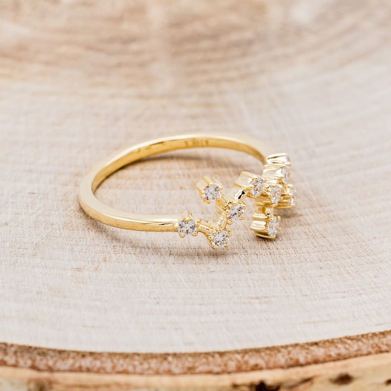 Shown here is "Zodiac", a custom, handcrafted women's stacker featuring a Sagittarius constellation on a 14K gold band, facing right. People born between the dates of November 22nd – December 21st are a Sagittarius.