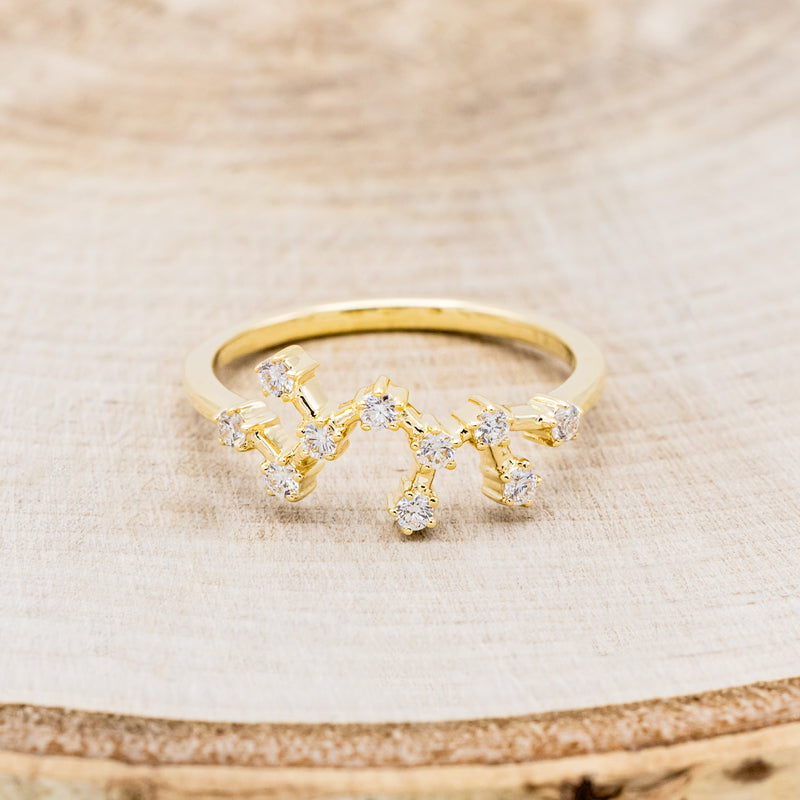 Shown here is "Zodiac", a custom, handcrafted women's stacker featuring a Sagittarius constellation on a 14K gold band, front facing. People born between the dates of November 22nd – December 21st are a Sagittarius.