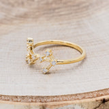 Shown here is "Zodiac", a custom, handcrafted women's stacker featuring a Scorpio constellation on a 14K gold band, facing left. People born between the dates of October 23rd – November 21st are a Scorpio.
