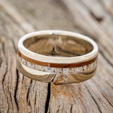 Shown here is "Castor", a custom, handcrafted men's wedding ring featuring ai ironwood and antler inlay on a 14K gold band, laying flat. Additional inlay options are available upon request.