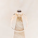 Shown here is "Diana", an oval smoky quartz women's engagement ring with a diamond halo and diamond accents, side view on stand. Many other center stone options are available upon request.