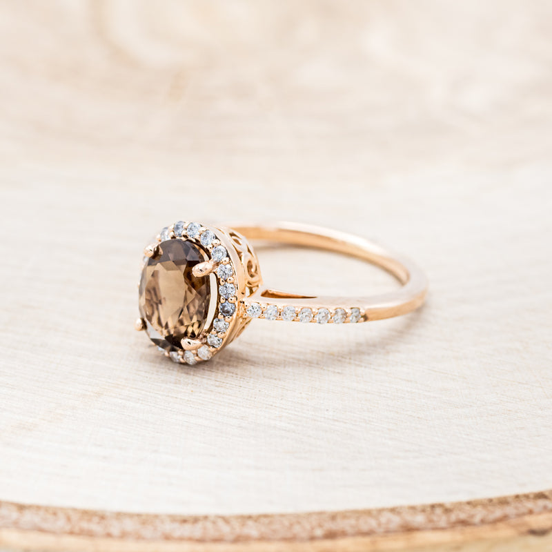 Shown here is "Diana", an oval smoky quartz women's engagement ring with a diamond halo and diamond accents, facing left. Many other center stone options are available upon request.