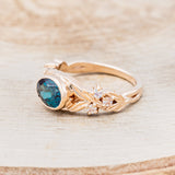 Shown here is "Elora", a vintage-style oval lab-created alexandrite women's engagement ring with floral details and moonstone accents, facing left. Many other center stone options are available upon request.