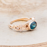 Shown here is "Elora", a vintage-style oval lab-created alexandrite women's engagement ring with floral details and moonstone accents, facing right. Many other center stone options are available upon request.