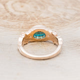 Shown here is "Elora", a vintage-style oval lab-created alexandrite women's engagement ring with floral details and moonstone accents, back view. Many other center stone options are available upon request.