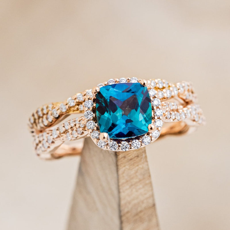 Shown here is "Kinley", a lab-created alexandrite women's engagement ring with a diamond halo, diamond accents and a diamond tracer, on stand front facing. Many other center stone options are available upon request. 