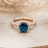 Shown here is "Kinley", a lab-created alexandrite women's engagement ring with a diamond halo and diamond accents, front facing. Many other center stone options are available upon request.