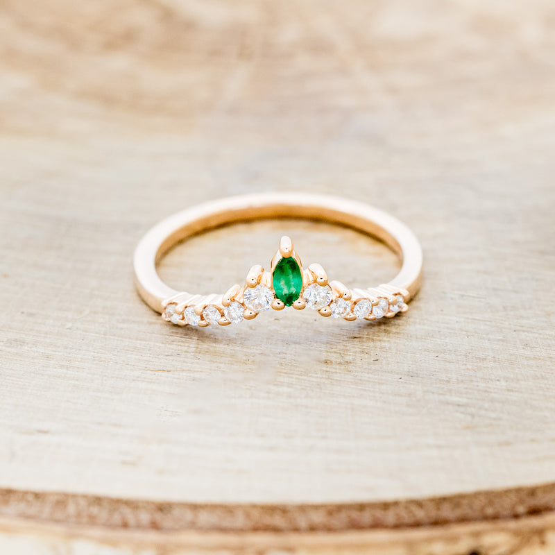 Shown here is "Sage" tracer, an emerald women's band with diamond accents, front facing. Many other center stone options are available upon request.
