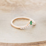 Shown here is "Sage" tracer, an emerald women's band with diamond accents, facing right. Many other center stone options are available upon request.