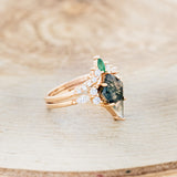 Shown here is "Sage", a moss agate women's engagement ring with diamond accents and an emerald tracer, facing right. Many other center stone options are available upon request.