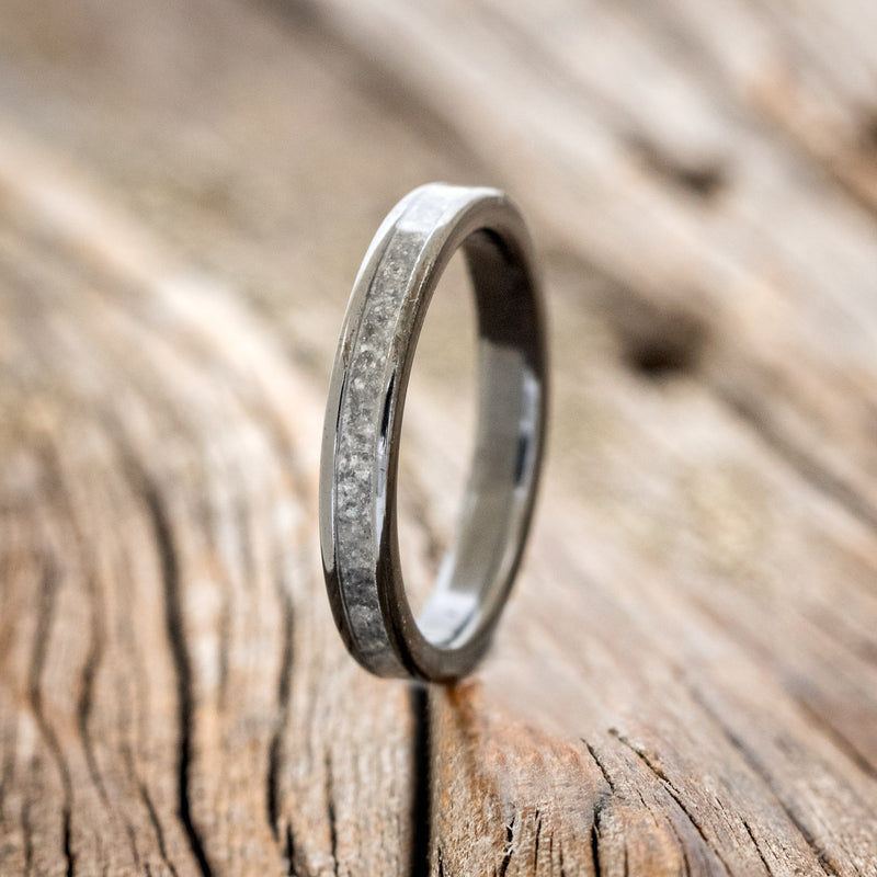 Shown here is "Perenna", a custom, handcrafted women's stacking band featuring a crushed moonstone inlay on a fire-treated black zirconium band, upright facing left. Additional inlay options are available upon request.
