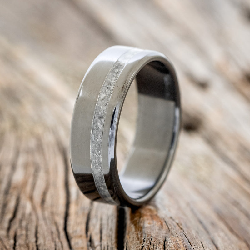 Shown here is "Vertigo", a handcrafted wide wedding band featuring an offset crushed moonstone inlay, upright facing left.